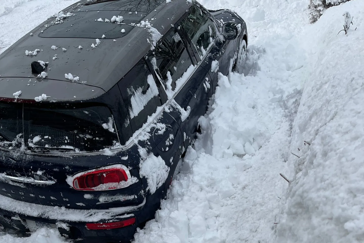 Car parked in deep snow after a winter storm